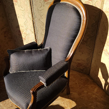 Fauteuil voltaire à crémaillère permettant de basculer légèrement le dossier en arrière, préfiguration du fauteuil relax.